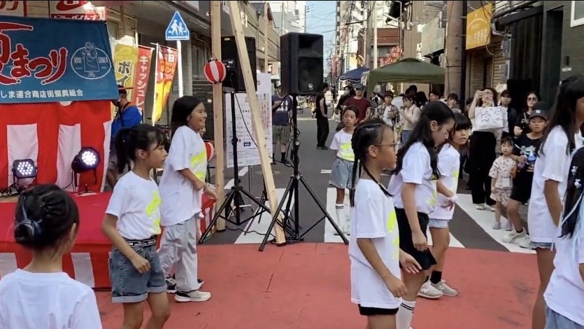 商店街の通りで元気に踊るアイズキッズダンススクールの皆さん